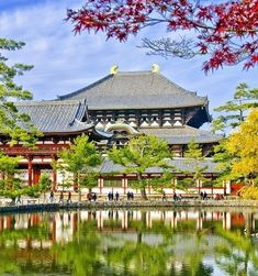 a large building with trees and water in front of it