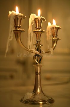 three candles are lit in the middle of a candle holder with white frost on it