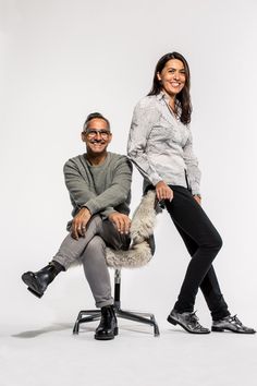 a man and woman sitting on a chair posing for the camera with their legs crossed