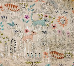 an old quilt with animals and flowers on it