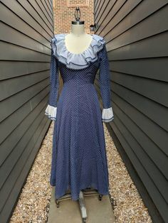 "A beautiful 1960s-70s blue polka dot dress with ruffle collar and sleeve cuffs!! Fully Lined. Has a very fitted bodice and dramatic skirt. In Good condition.The lining has discoloration. No label, see measurements below for sizing. Most Likely polyester Garment Measured Flat (In inches) Bust: 33\" Waist: 37\" Hip: 40\" Length: 45 1/2\" Sleeve Length: 23\" Armhole opening: 19\" Sleeve opening: 9\"" Fitted Long Sleeve Swiss Dot Dresses, Vintage Blue Dress With Ruffle Hem, Retro Vintage Dress With Ruffles For Fall, Retro Fitted Dress With Ruffle Hem, Fitted Prairie Dress With Ruffles For Fall, Vintage Long Sleeve Polka Dot Dress, Vintage Polka Dot Long Sleeve Dresses, Fitted Retro Swiss Dot Dress, Retro Fitted Swiss Dot Dress