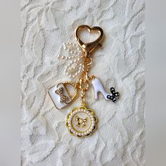 a keychain with some charms attached to it on a white lace table cloth