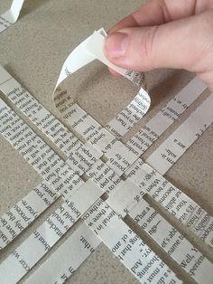 someone is cutting out strips of paper from the ground with scissors and tape on them