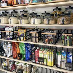 the shelves are full of various types of food and drink in bins on them