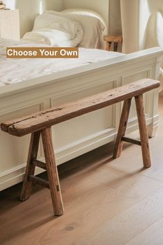 a wooden bench sitting in front of a bed with the words choose your own on it