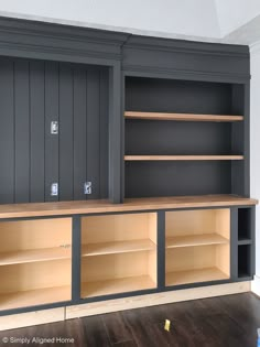 an empty entertainment center with shelves and cupboards