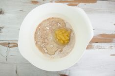 a white bowl filled with oatmeal topped with banana slices and powdered sugar