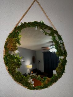 a mirror hanging on the wall with moss