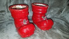 two red boots sitting on top of a gray couch next to each other and covered in white stuff