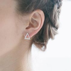 The Triangle earring studs have been hand carved and display dash detailing around the perimeters forming the geometric shapes; triangle, hexagon, rectangle in the suite.Earring studs are available in these materials; bright white sterling silver, oxidised (black) sterling silver, 14K gold.NOTES:Suite of three12mm height10.5mm width0.6mm gauge- Abby Seymour is an Australian jeweller renowned for her distinctive print mark making signature style. Her diverse designs entail detailed and intricate Triangle Stud Earrings, Triangle Earrings Stud, Minimal Earrings, Triangle Studs, Geometric Studs, Packaging Gift, Classic Earrings, Triangle Earrings, White Gold Earrings