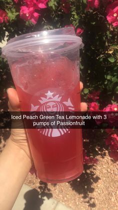 someone holding up a cup of tea with the words iced peach green tea lemonade with 3 plumps of passion fruit