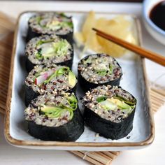 some sushi is sitting on a plate with chopsticks