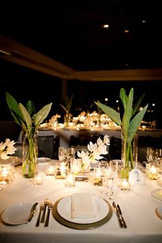 the table is set with white flowers and candles