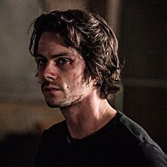 a close up of a person wearing a black shirt with blood on his face and eyes