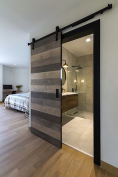 an open sliding door leading to a bedroom with a bed in the background and wooden flooring