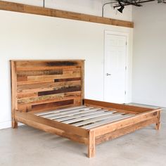 a bed made out of pallet wood in a room with white walls and flooring