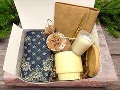 an open box filled with personal items on top of a wooden table next to greenery