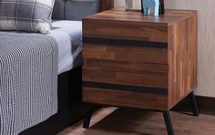 a bed with a wooden night stand next to it