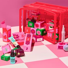 an assortment of beauty products on a pink and white checkered surface