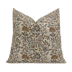 a brown and white floral pillow on a white background with an orange flower design in the center