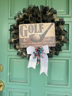 a golf themed door hanger on a green front door with a white bow and black mesh wreath