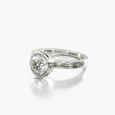 a white gold ring with a round diamond in the center