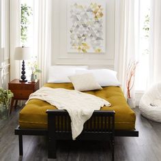 a bedroom with white walls and wood floors