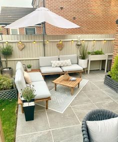 a patio with couches, tables and an umbrella