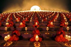 there are many buddhas sitting on the steps with wine glasses in front of them