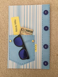 a pair of sunglasses sitting on top of a blue and white striped piece of paper