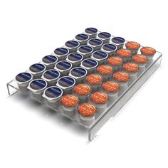 several rows of orange and blue cupcakes on a metal rack with white background