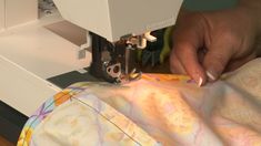 someone is using a sewing machine to sew fabric