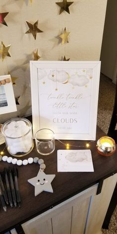 a table topped with candles and decorations next to a star shaped wall hanging from the ceiling