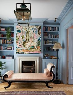 a living room filled with furniture and a fire place in front of a book shelf