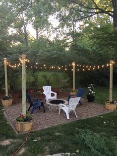 an outdoor patio with chairs and lights strung over it, surrounded by trees in the background