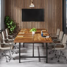 an empty conference room with chairs and a wooden table in front of a flat screen tv