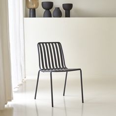 a black chair sitting in front of a white wall