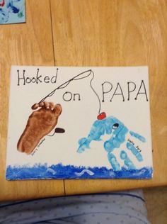 a child's hand and foot are on the floor next to a sign that says hooked on papa