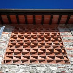 a close up of a brick wall with an opening in the middle that has triangles on it