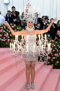 lady in white dress with chandelier on pink carpet