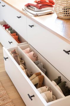 an open drawer with several pairs of shoes in it next to a basket on the counter