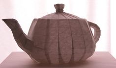 a teapot made out of paper sitting on top of a table