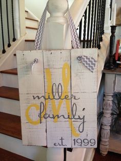 a wooden sign that says miller family at the bottom and yellow letters on it in front of some stairs