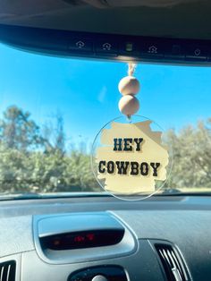 a car dashboard with the words hey cowboy hanging from it