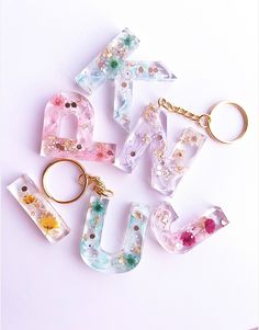 the letters are made out of plastic and have flowers on them, as well as a keychain