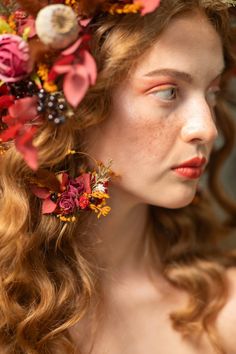 a woman with flowers in her hair is wearing a flower headpiece and looking off to the side