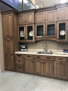 a kitchen with wooden cabinets and white counter tops in a showroom area at a furniture store