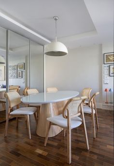 a dining room table surrounded by chairs and mirrors