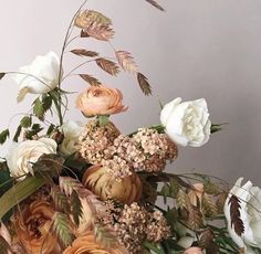 a vase filled with lots of flowers on top of a table