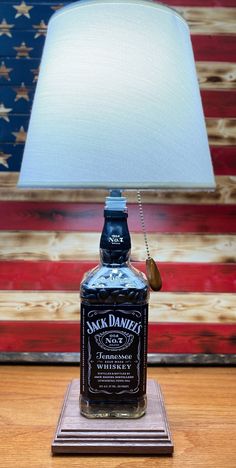 a lamp that is sitting on top of a wooden table with an american flag in the background